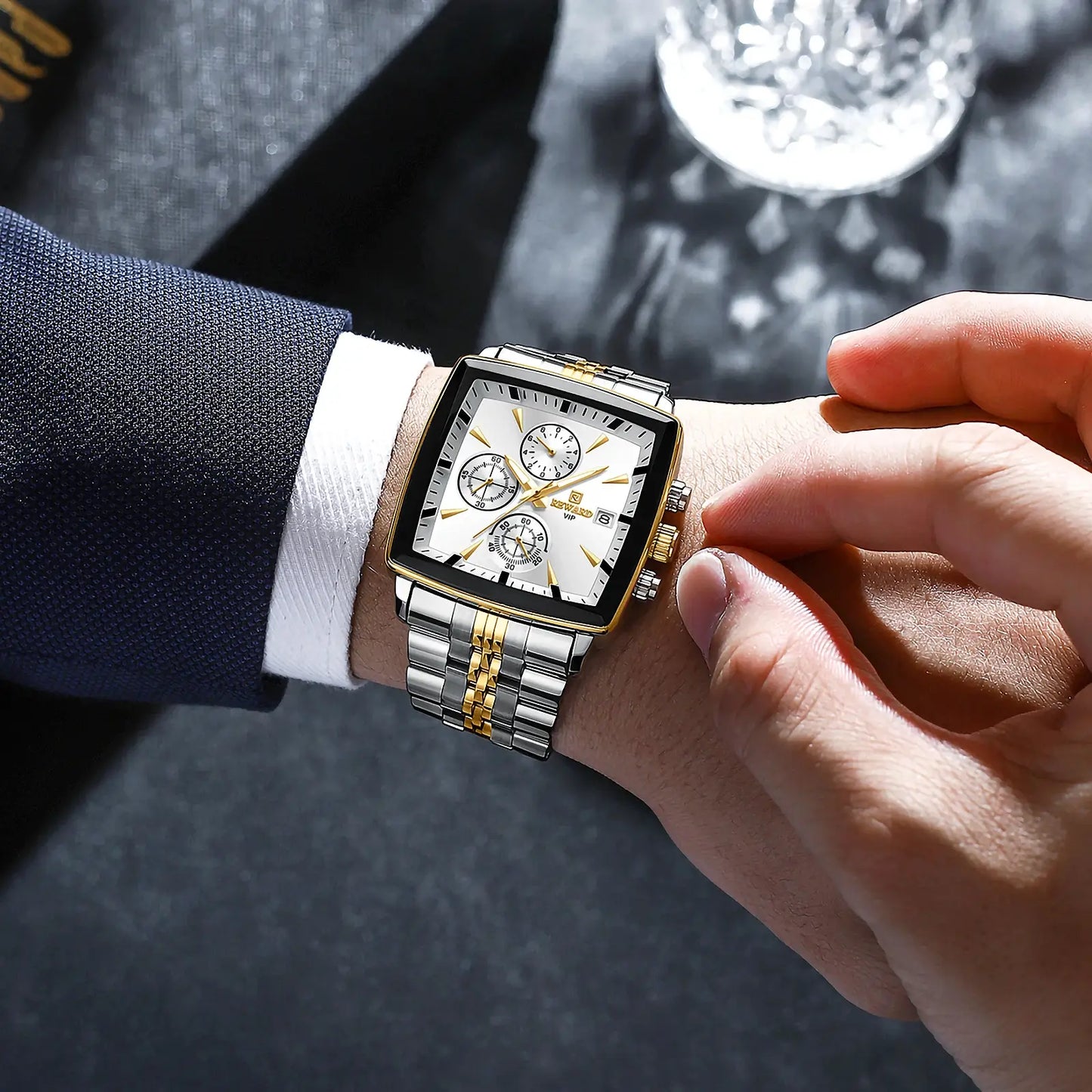 homem de terno elegante usando relógio masculino reward vip monaco dourado com prata com formato quadrado e mecanismo quartzo.
