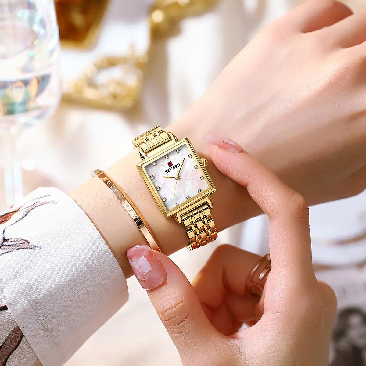 Relógio quadrado feminino pequeno dourado Reward VIP Élise sob o pulso de um ângulo mais aproximado