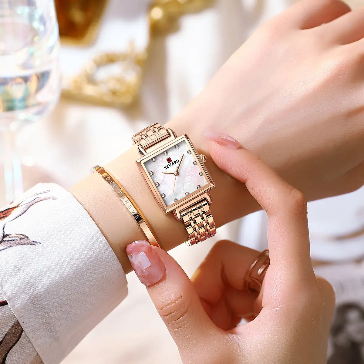 Relógio quadrado feminino pequeno cor ouro rosa modelo Reward VIP Élise sendo utilizado no pulso com vista de outro ângulo