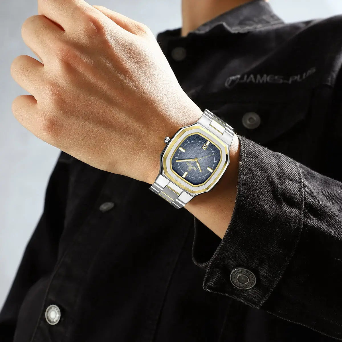 Relógio social masculino com pulseira de aço prata com elo central dourado e mostrador azul utilizado no pulso