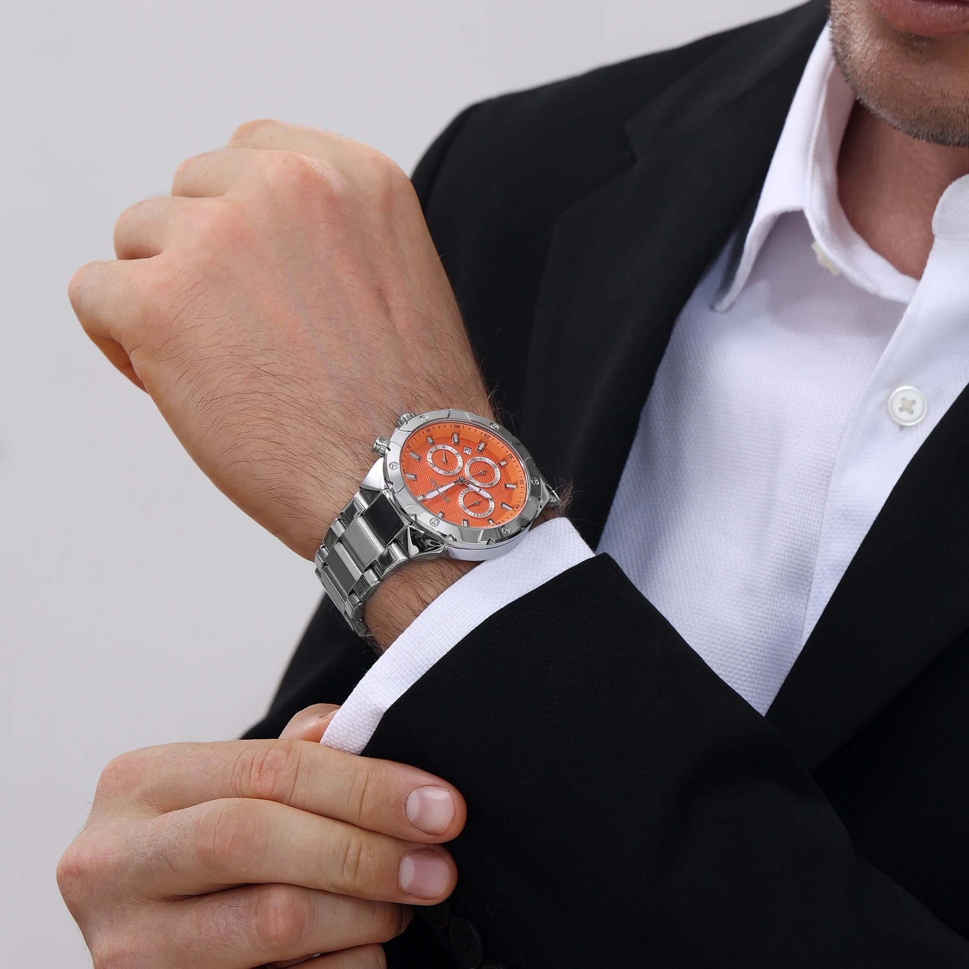 Homem usando relógio masculino REWARD VIP Legacy com mostrador laranja e pulseira de aço inoxidável, combinando com traje social.