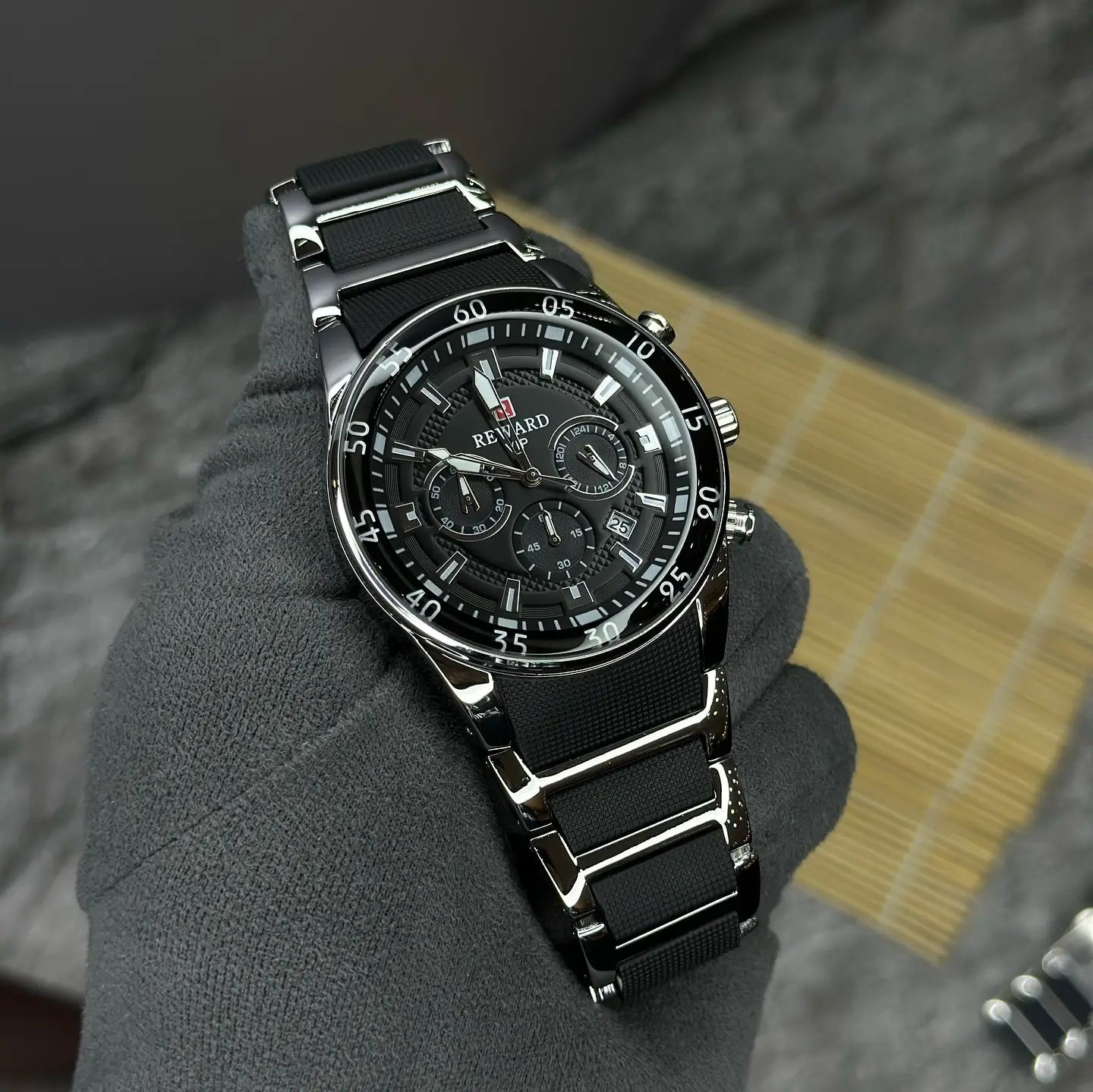 Relógio masculino prata e preto Reward VIP Cronos Sport visto de cima, destacando o mostrador esportivo preto, a pulseira metálica e o acabamento robusto da caixa