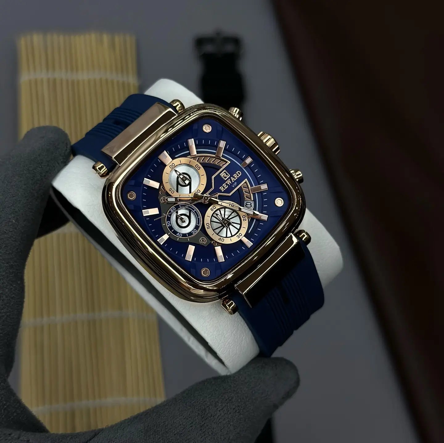 Relógio masculino quadrado azul Reward VIP Monaco Sport com mostrador azul e detalhes em rose gold, visto de forma ampliada com parte da caixa e pulseira