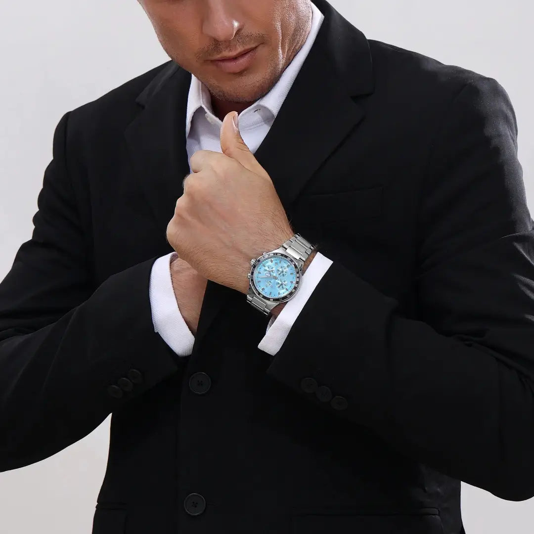 Homem elegante usando relógio masculino REWARD VIP Magnus com mostrador azul e pulseira de aço inox, estilo sofisticado no pulso.