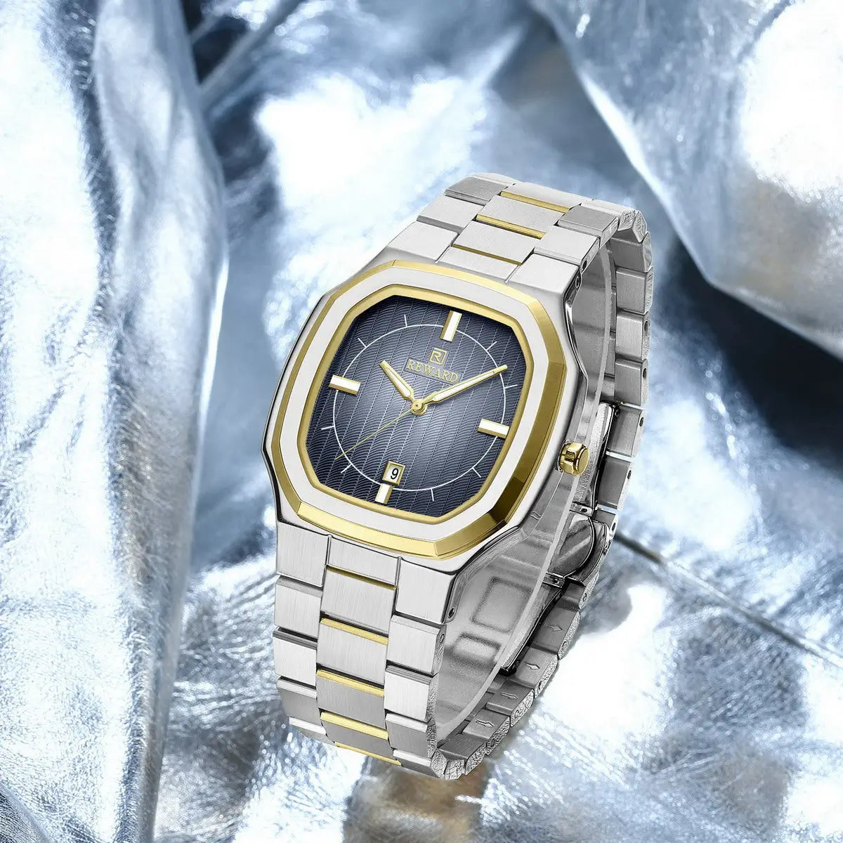 Relógio social masculino com pulseira de aço prata com elo central dourado e mostrador azul vista do mostrador de outro ângulo