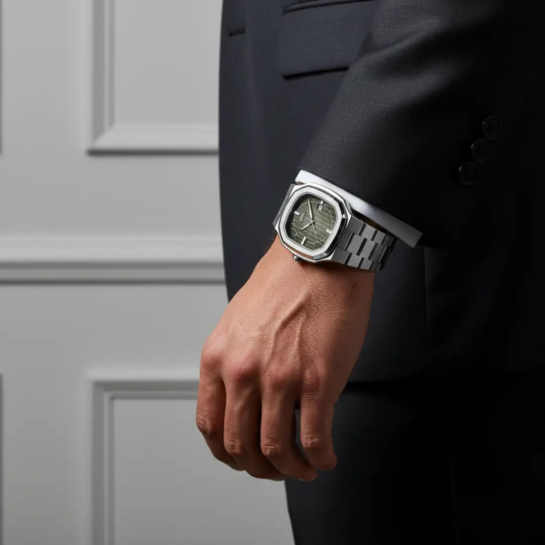 Relógio social masculino Signature prata com caixa octogonal de 38mm e mostrador verde no pulso, combinado com terno.